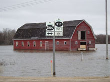 Photo of red barn surrounded by water from the Red River floods. Photo: Rod Zemianski © Environment Canada, 2009