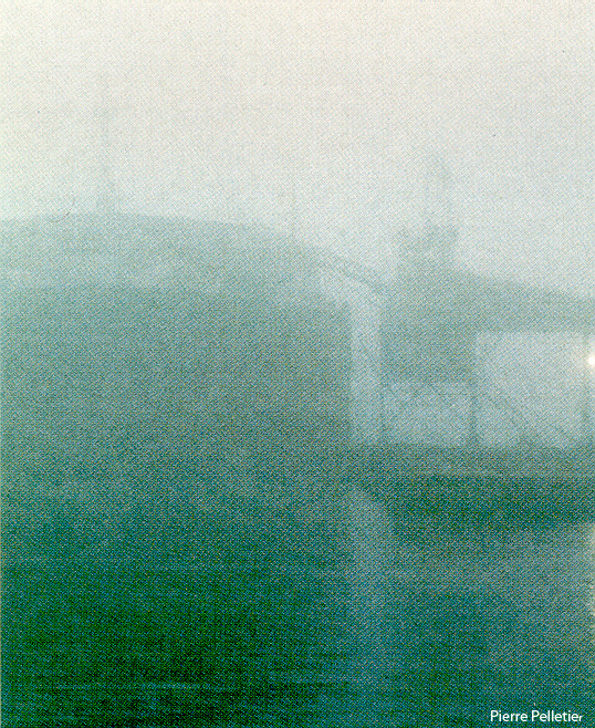 Un épais brouillard obscurcit un bateau à peine visible.