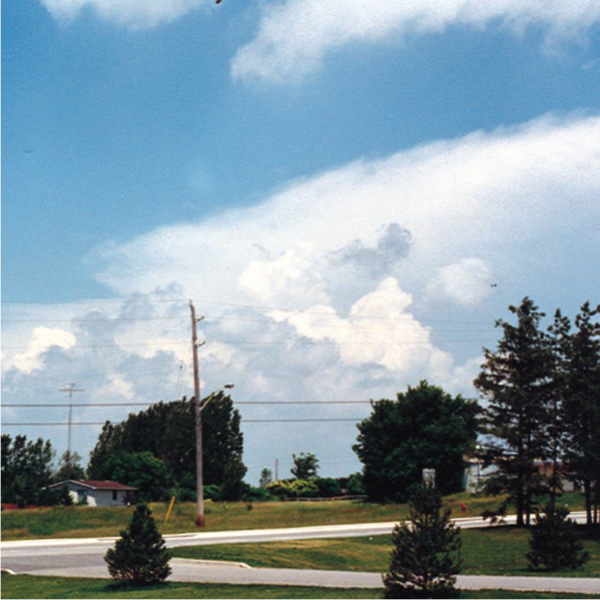 A cumulonimbus cloud in the distance with an anvil and towering cumulus in front of it