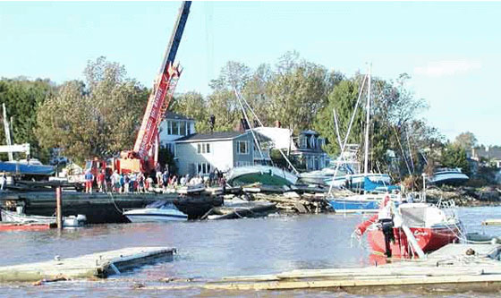 Submerged and grounded boats at the Bedford Yacht Club being righted by a crane. Photo: Roger Percy and Andre Laflamme